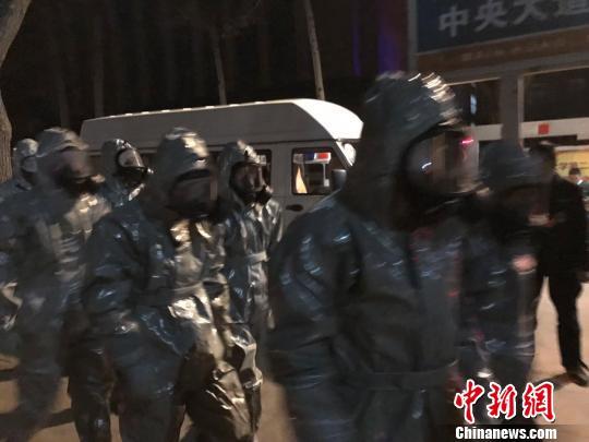 十几名身着防护服的人员头戴面具进入事发地。　胡健 摄